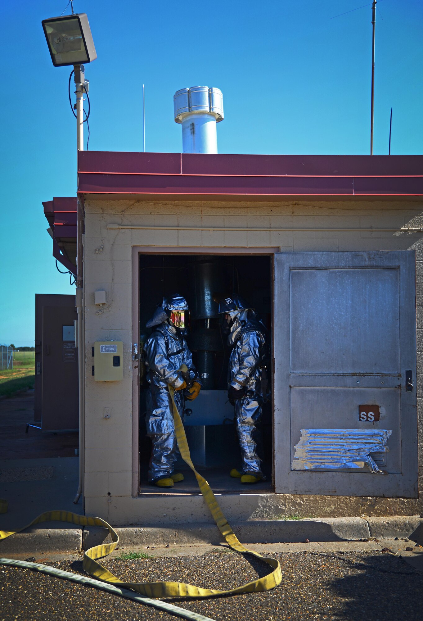 Firefighters with the 27th Special Operations Civil Engineer Squadron simulate clearing a building during an exercise Aug. 4, 2015 at Cannon Air Force Base, N.M. While Cannon firefighters were in no actual danger, evaluators were on site injecting additional benchmarks to add to the realism of the exercise scenario. (U.S. Air Force photo/Staff Sgt. Alexx Mercer)