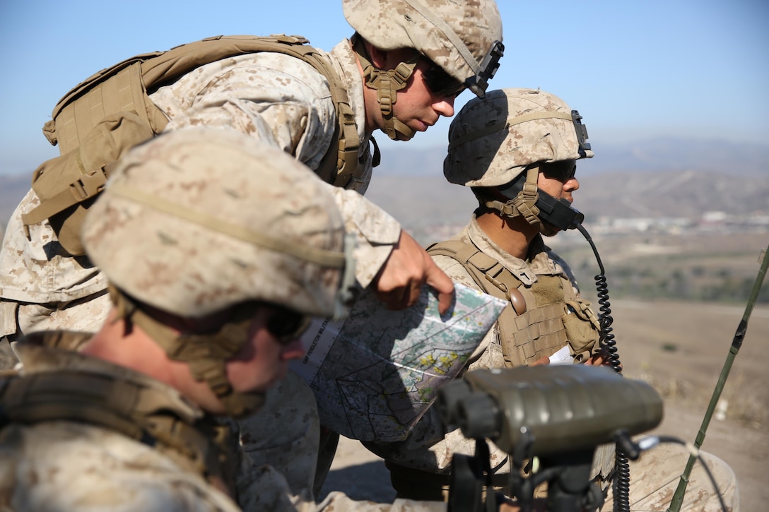 1st Lt. Mark Null (center), an artillery officer assigned to 2nd Battalion, 11th Marine Regiment, 1st Marine Division, shows coordinates to his radio operator in order to call for fire, aboard Marine Corps Base Camp Pendleton, Calif., Aug. 14, 2015. 2/11 annually conducts Summer Fire Exercise to sustain core proficiencies and to further develop their ability to execute fire missions.