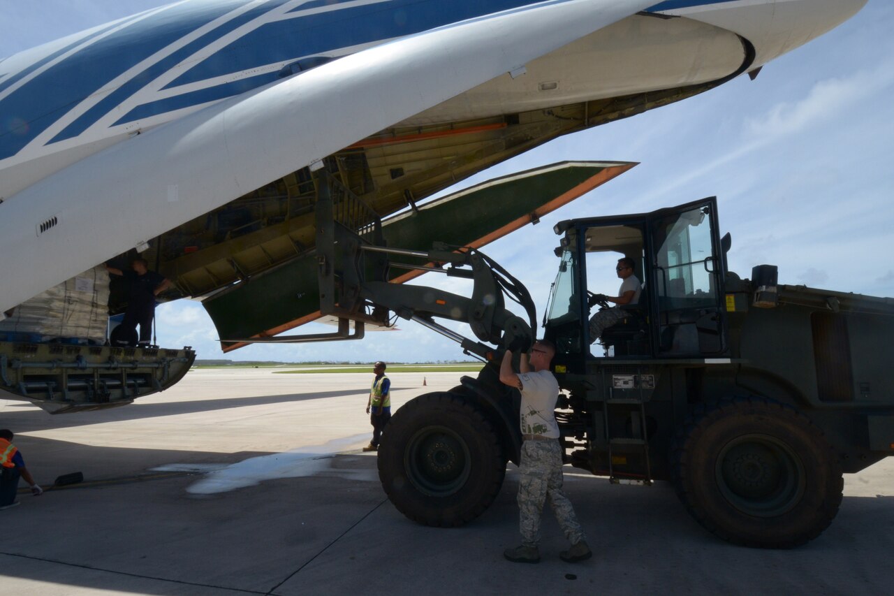 U.S. airmen unload a cargo plane full of supplies to be distributed to residents of Saipan. Airmen from the 36th Contingency Response Group deployed from Andersen Air Force Base as part of a coordinated effort with the Federal Emergency Management Agency and Red Cross to provide relief to island residents following Typhoon Soudelor. 