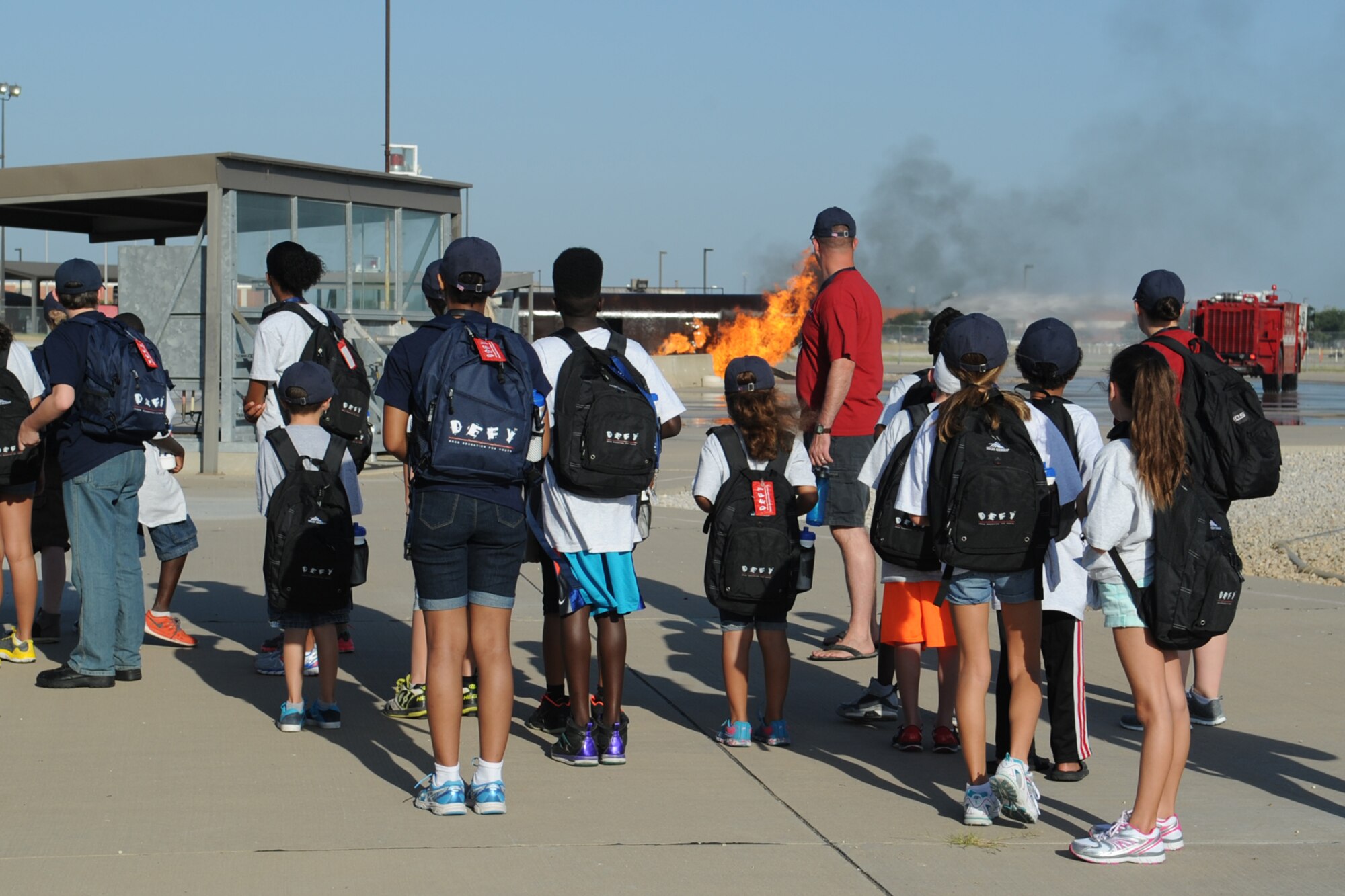 Drug Education for Youth participants watch 312th Training Squadron students put out a fire at the Louis F. Garland Department of Defense Fire Academy, Goodfellow Air Force Base, Texas, Aug. 6, 2015. The coordinators lined up several events for the children to go to, including trips to the Abilene Zoo and many more. (U.S. Air Force photo by Staff Sgt. Laura R. McFarlane/Released)