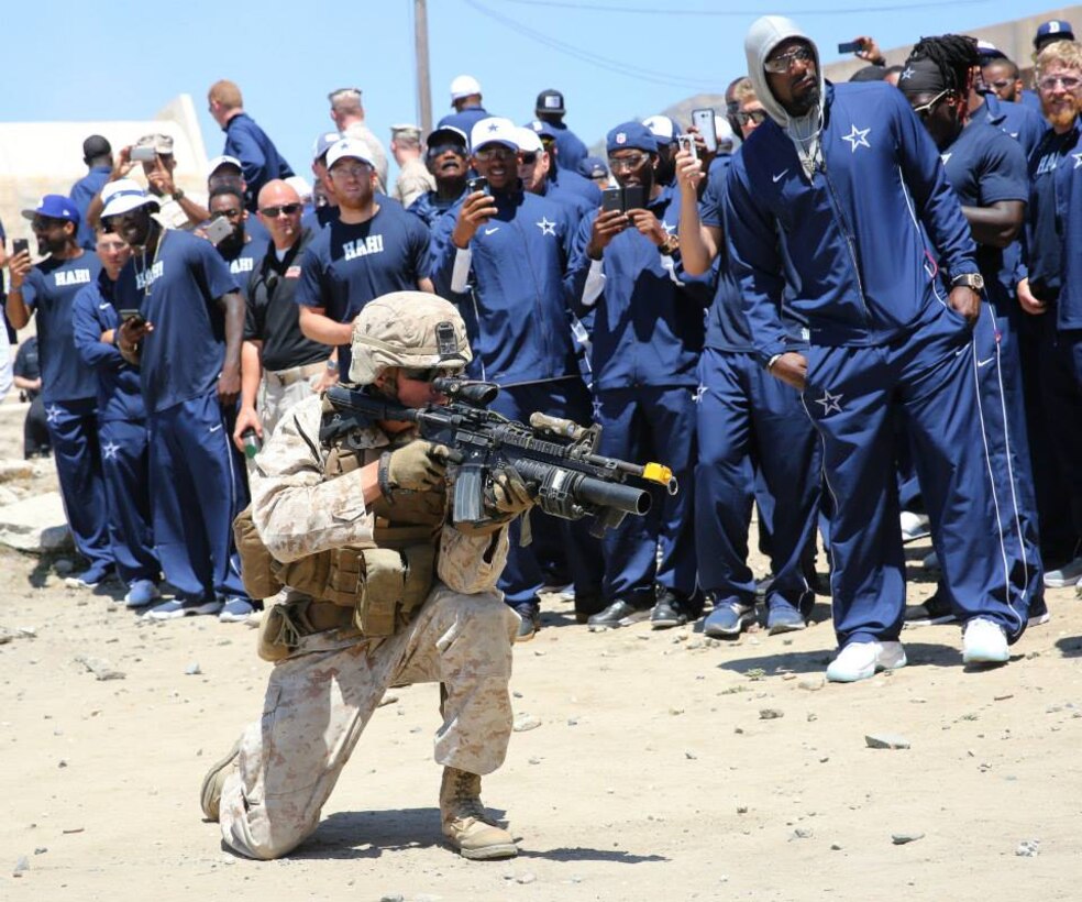 The Dallas Cowboys watch Marines and role players take part in a demonstration at the Infantry Immersion Trainer, August 12. The Infantry Immersion Trainer is a hands-on, mixed reality training facility that simulates the sights, smells, sounds and feel of a real village, in designated locations. The purpose of the facility is to provide a realistic environment in which to train Marines for deployment.