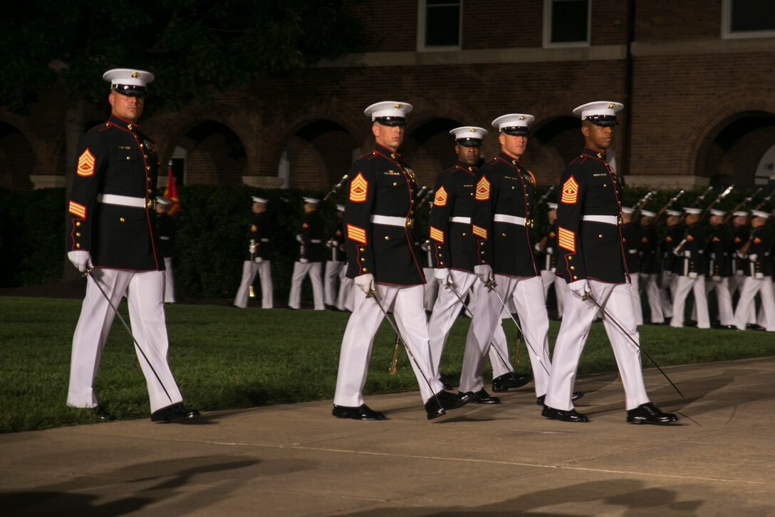 The parade staff performs during a Friday Evening Parade, Marine Barracks Washington, D.C., Aug. 14, 2015. The guest of honor for the Evening Parade was Lance Cpl. Joshua Leakey recipient of the Victoria Cross, the highest military decoration for valor in the British and Commonwealth armed forces, and the hosting official was Lt. Gen. Jon Davis, deputy commandant for Aviation. (U.S. Marine Corps photo by Cpl. Christian Varney/Released)