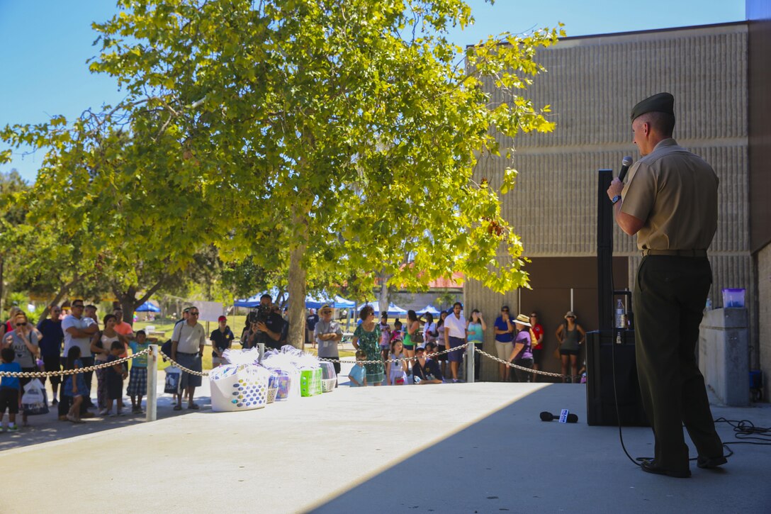 Col. John Farnam, commanding officer of Marine Corps Air Station Miramar, California, speaks to military families during the Military Family Enrollment and Appreciation Fair hosted by the San Diego Unified School District at Serra High School, Aug. 15. The fair offered military families an opportunity to enroll their children in school while enjoying games, prizes and a complimentary lunch.