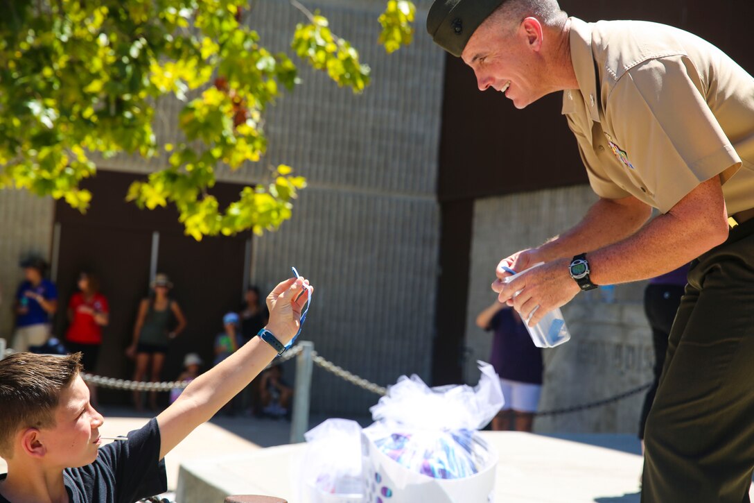 Col. John Farnam, commanding officer of Marine Corps Air Station Miramar, California, checks a students raffle ticket before giving him a prize during the Military Family Enrollment and Appreciation Fair hosted by the San Diego Unified School District at Serra High School, Aug. 15. The fair offered military families an opportunity to enroll their children in school while enjoying games, prizes and a complimentary lunch.