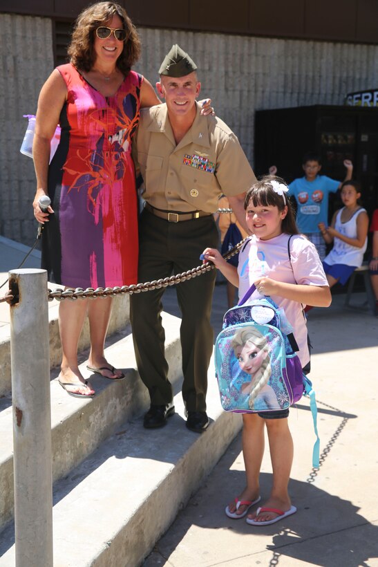 Col. John Farnam, commanding officer of Marine Corps Air Station Miramar, California, poses with families during the Military Family Enrollment and Appreciation Fair hosted by the San Diego Unified School District at Serra High School, Aug. 15. The fair offered military families an opportunity to enroll their children in school while enjoying games, prizes and a complimentary lunch.
