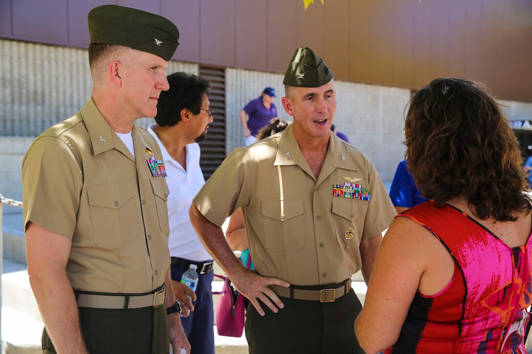 Col. John Farnam, commanding officer of Marine Corps Air Station Miramar, California, right, and Col. Jason Woodworth, oncoming commanding officer of MCAS Miramar, talks to families at the Military Family Enrollment and Appreciation Fair hosted by the San Diego Unified School District at Serra High School, Aug. 15. The fair offered military families an opportunity to enroll their children in school while enjoying games, prizes and a complimentary lunch.
