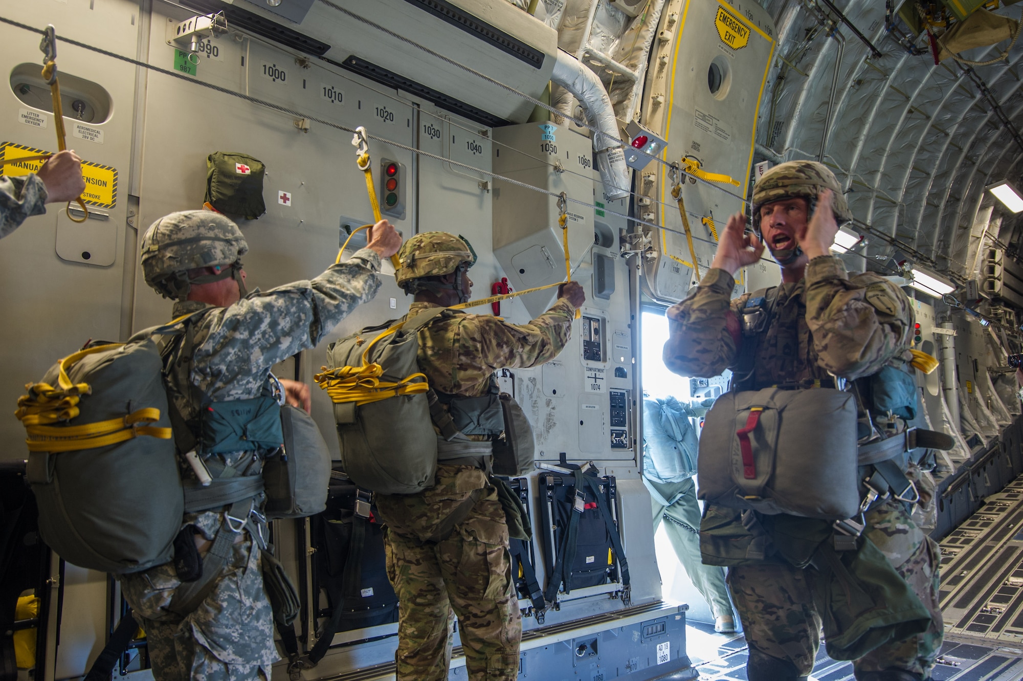 U.S. Army paratroopers listen to their jump master as they prepare to jump out of a C-17 Globemaster III Aug. 15, 2015 during a flight over Lawson Army Airfield, Fort Benning, Ga. Reserve aircrews from the 701st and 300th Airlift Squadron out of Joint Base Charleston, S.C. flew two C-17s during Fort Benning’s celebration of the 75th anniversary of the U.S. Army Airborne School. Almost 300 paratroopers took the big leap in the day’s event. (U.S. Air Force photo by Staff Sgt. Bobby Pilch)