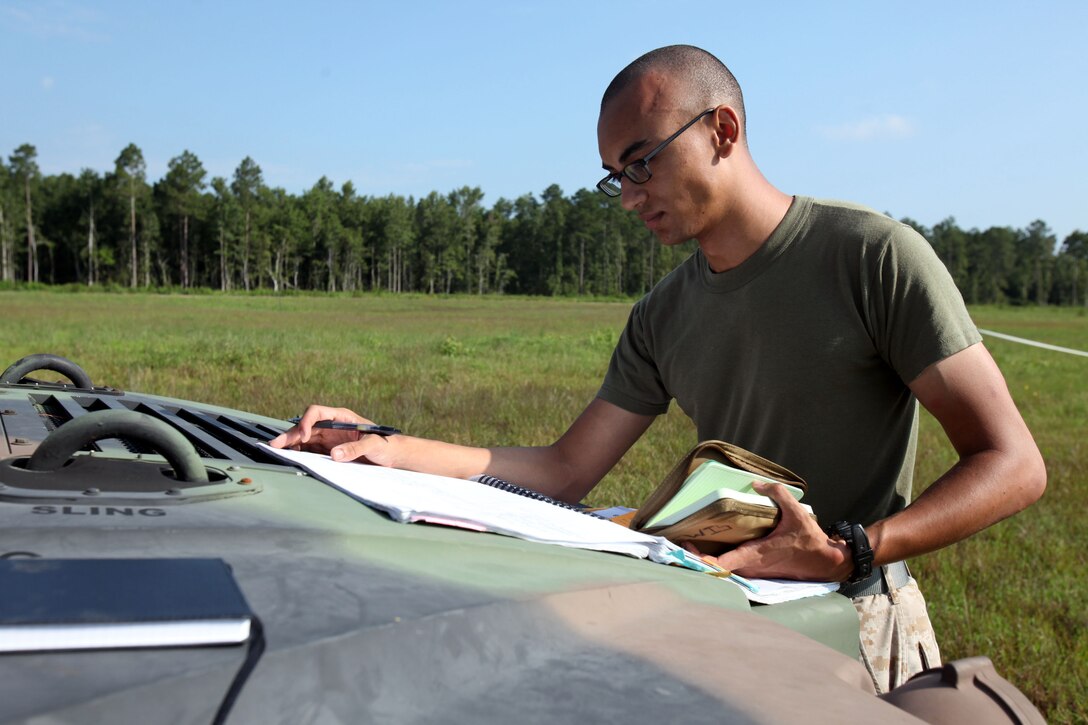 Lance Cpl. Nicholas Lewis goes over schematics for the equipment used during Marine Wing Communications Squadron 28’s field training exercises at Camp Davis and Outlying Landing Field Atlantic, North Carolina, Aug.12, 2015. The training served as a refresher course and is typically held anywhere from two to three times per year for tropospheric scatter radio multi-channel equipment-related military occupational specialties in the squadron. Lewis is a digital wideband repair technician with MWCS-28.