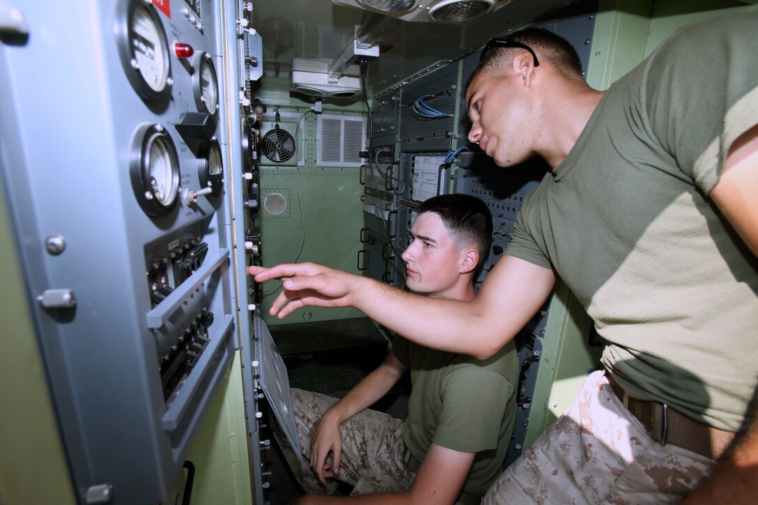 Cpl. Valentino Lopez, right, shows Lance Cpl. Michael Krouse how to operate AN/TRC170 equipment during Marine Wing Communications Squadron 28’s field training exercise at Camp Davis and Outlying Landing Field Atlantic, North Carolina, Aug.12, 2015. The training served as a refresher course and is typically held anywhere from two to three times per year for tropospheric scatter radio multi-channel equipment-related military occupational specialties in the squadron. Krouse and Lopez are both tropospheric scatter radio multi-channel equipment operators with MWCS-28.