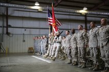 Marines with Special Purpose Marine Air Ground Task Force-Crisis Response-Central Command and Airmen with 332nd Air Expeditionary Wing  stand at attention as the color guard marches in the colors during the 7th Marine Regiment’s 98th anniversary ceremony held in an undisclosed location in Southwest Asia, Aug. 15, 2015. The 7th Marine Regiment Headquarters and 3rd Battalion, 7th Marines are currently deployed with the SPMAGTF-CR-CC and took time to remember the regiment’s storied history and rededicate themselves to their current work with Operation Inherent Resolve.