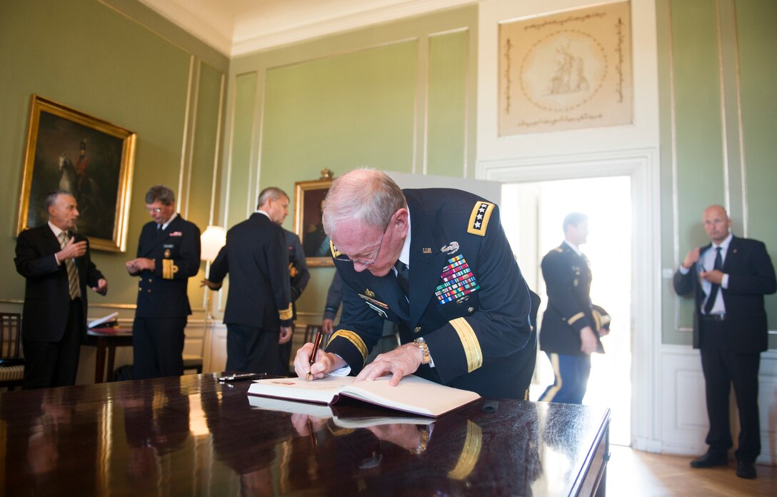 U.S. Army Gen. Martin E. Dempsey, chairman of the Joint Chiefs of Staff, writes a message in the guest book of the Royal Danish Army Academy in Copenhagen, Denmark, Aug. 17, 2015. DoD photo by D. Myles Cullen