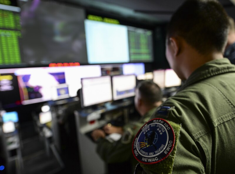 U.S. Air Force Capt. Ernie Chen, 961st Airborne Air Control Squadron evaluator electronics combat officer, coordinates air operations with a team of Airmen who belong to various units across the globe at the Hardened Theater Air Control Center, Osan Air Base, Republic of Korea, during the first day of Ulchi Freedom Guardian, Aug. 17, 2015. UFG is a realistic training event focused on preparing, preventing and prevailing against the full range of current and future threats to the ROK and the region. Portions of the image were blurred for security concerns. (U.S. Air Force illustration/Airman 1st Class John Linzmeier)
