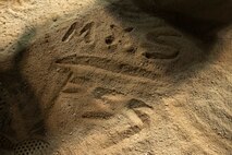 A member of the 8th Maintenance Squadron Dragons writes the teams name on the field after the intramural softball championship game at Kunsan Air Base, Republic of Korea, Aug. 17, 2015. The MXS finished off a great season with a 10-1 record and its second championship in a row. (U.S. Air Force photo by Senior Airman Divine Cox/Released) 