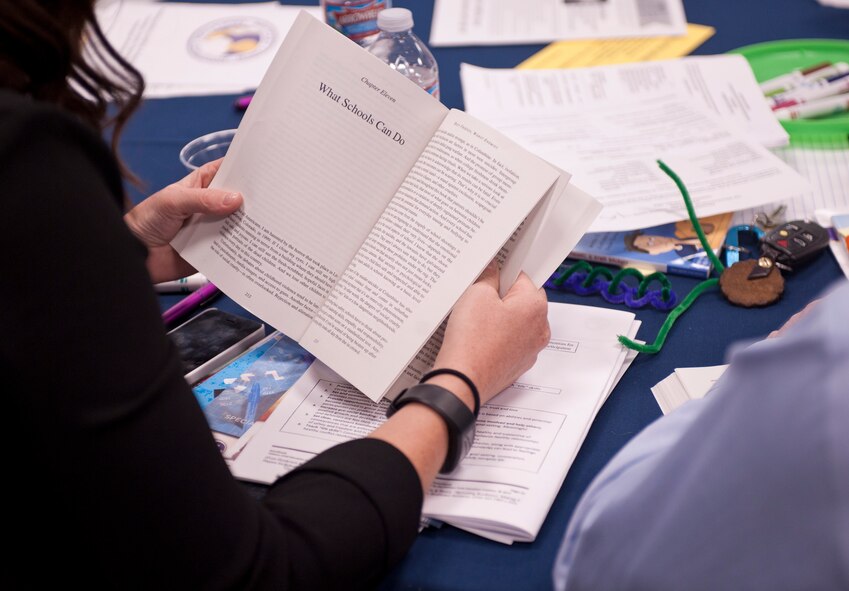 An attendee of the Military Child Education Coalition workshop reads a section of text about different possibilities for benefiting military children in school Aug. 7, 2015, in the Red Morgan Center at Fairchild Air Force Base, Wash. The goal of the workshop was for each of the participants to be able to bring back to their schools a customized action plan to benefit the military children enrolled there. (U.S. Air Force photo/Airman Sean Campbell)
