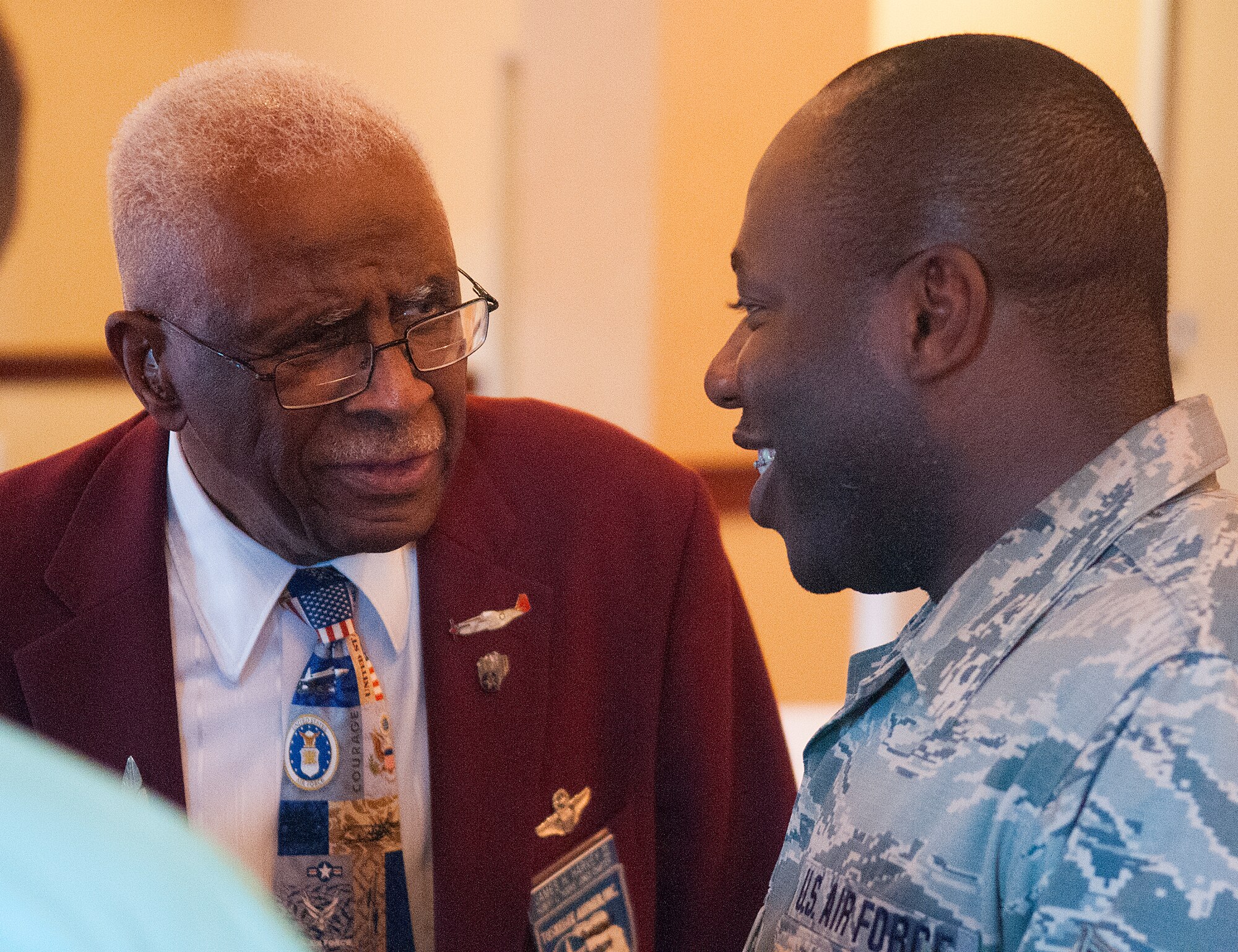 Retired Lt. Col. James Harvey III, one of the original Tuskegee pilots, speaks with Senior Airman Aaron Snow, 153rd Comptroller Squadron, during a reception in honor of the Tuskegee Airmen at the Historic Plains Hotel, Cheyenne, Wyo., August 14, 2015. Harvey and Snow discussed the difference in their careers in the military and how many opportunities there are for people of any race in today's Air Force. (U.S. Air Force photo by Airman 1st Class Brandon Valle)