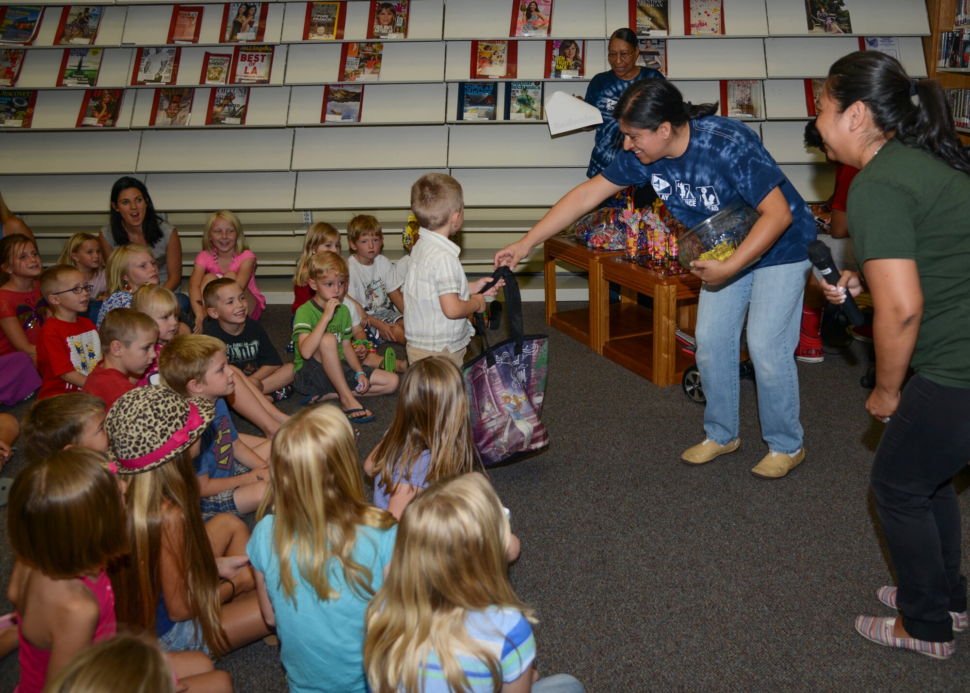 Alison Vasquez, library director, hands out a raffle prize during the final Summer Reading Program event of the year. Children who completed all 100 books during the program were entered into a raffle for the largest prizes. (U.S. Air Force photo by Rebecca Amber)