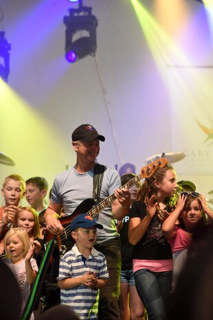 Gary Sinise, actor and Lt. Dan Band co-founder, plays a concert outside of Malmstrom Air Force Base’s Fitness and Sports Center Aug. 16. During the show, Sinise brought children from the crowd on stage to sing along with him. (U.S. Air Force photo/Airman 1st Class Collin Schmidt) 