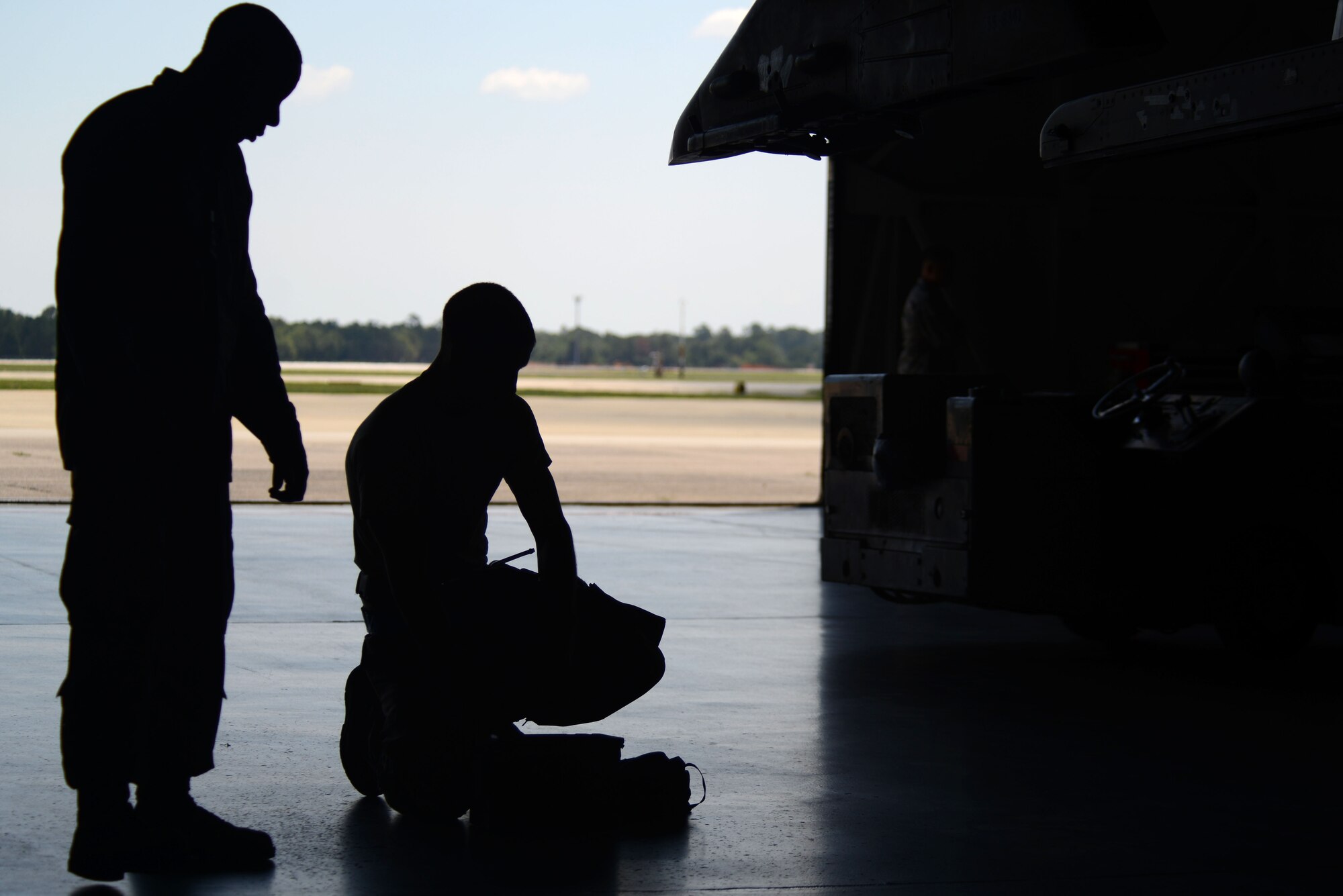 A U.S. Air Force Airman from the 20th Equipment Maintenance Squadron searches through his tools under the watchful eye of an evaluator during a weapons load crew of the quarter competition at Shaw Air Force Base, S.C., Aug. 14, 2015. During this round of the competition, the 20th EMS competed against the 20th Aircraft Maintenance Squadron, 55th Aircraft Maintenance Unit to determine who could load munitions onto an F-16CM Fighting Falcon the fastest. (U.S. Air Force photo by Airman 1st Class Kelsey Tucker/Released)