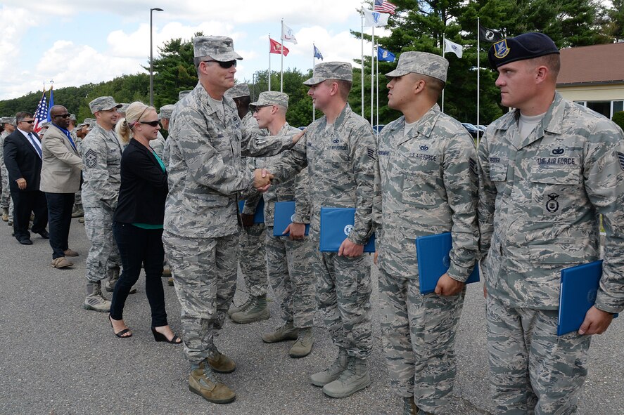 Col. Michael A. Vogel, and his wife, Misty, as well as Hanscom Command Chief Master Sgt. Craig A. Poling and other 66th Air Base Group senior leaders pass through a receiving line following a U.S. Air Force Honor Guard Formal Training graduation ceremony outside the Patriot Honor Guard building Aug. 12. Honor Guard members from the Hanscom-based Patriot Honor Guard, Air National Guard and Air Force Reserve attended the training. (U.S. Air Force photo by Linda LaBonte Britt)