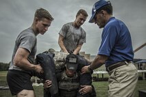 A female subject wears a 20-pound vest and 50-pound rucksack while lifting a 185-pound simulated casualty, June 19, 2015, as researchers from the Air Force Fitness Testing and Standards Unit ensure her safety. The Airman is a volunteer supporting the Physical Fitness Tests and Standards study at Joint Base San Antonio-Lackland, Texas. The study aims to establish occupationally-specific, operationally-relevant physical fitness standards for Battlefield Airmen. The small unit tactics simulation is one of 15 simulations designed to capture the most arduous physical demands of Battlefield Airmen. (U.S. Air Force Photo by 1st Lt. Jose R. Davis)

