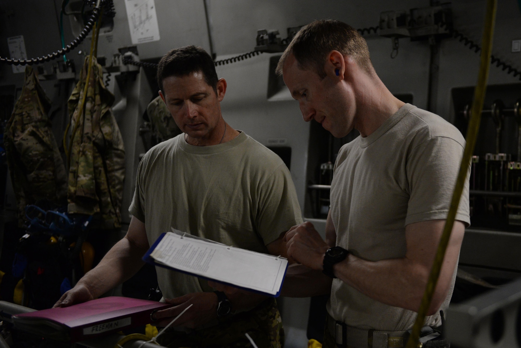 U.S. Air Force Maj. Jonathan Freeman (left), 455th EAES medical crew director and flight nurse deployed from the North Carolina Air National Guard’s 156th Air Expeditionary Squadron, and U.S. Air Force Capt. Derek Martindale (right), 455th EAES flight nurse deployed from the Air Force Reserve’s 315th Aeromedical Evacuation Squadron, review checklists prior to an AE mission on a C-17 Globemaster III aircraft on the flight line at Bagram Airfield, Afghanistan, Aug. 8, 2015.  The 455th EAES Airmen are charged with the responsibility of evacuating the sick and wounded from Central Command to higher echelons of medical care. (U.S. Air Force photo by Maj. Tony Wickman/Released) 