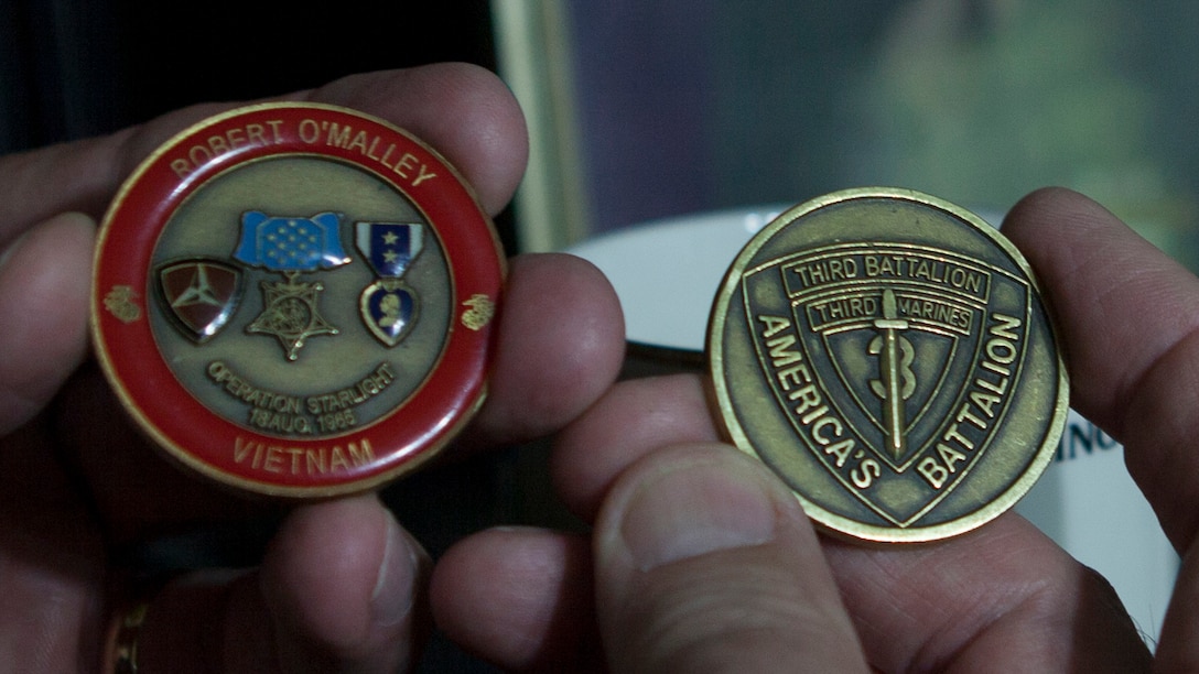 Charles "Charlie" Fink, Marine Vietnam veteran, holds specialty-made commemorative Marine Corps challenge coins June 2, 2015 at his home in Lake Butler. The coin on the left is for Marine veteran Sgt. Robert O’Malley, who was awarded the Medal of Honor for his actions during Operation Starlite. 