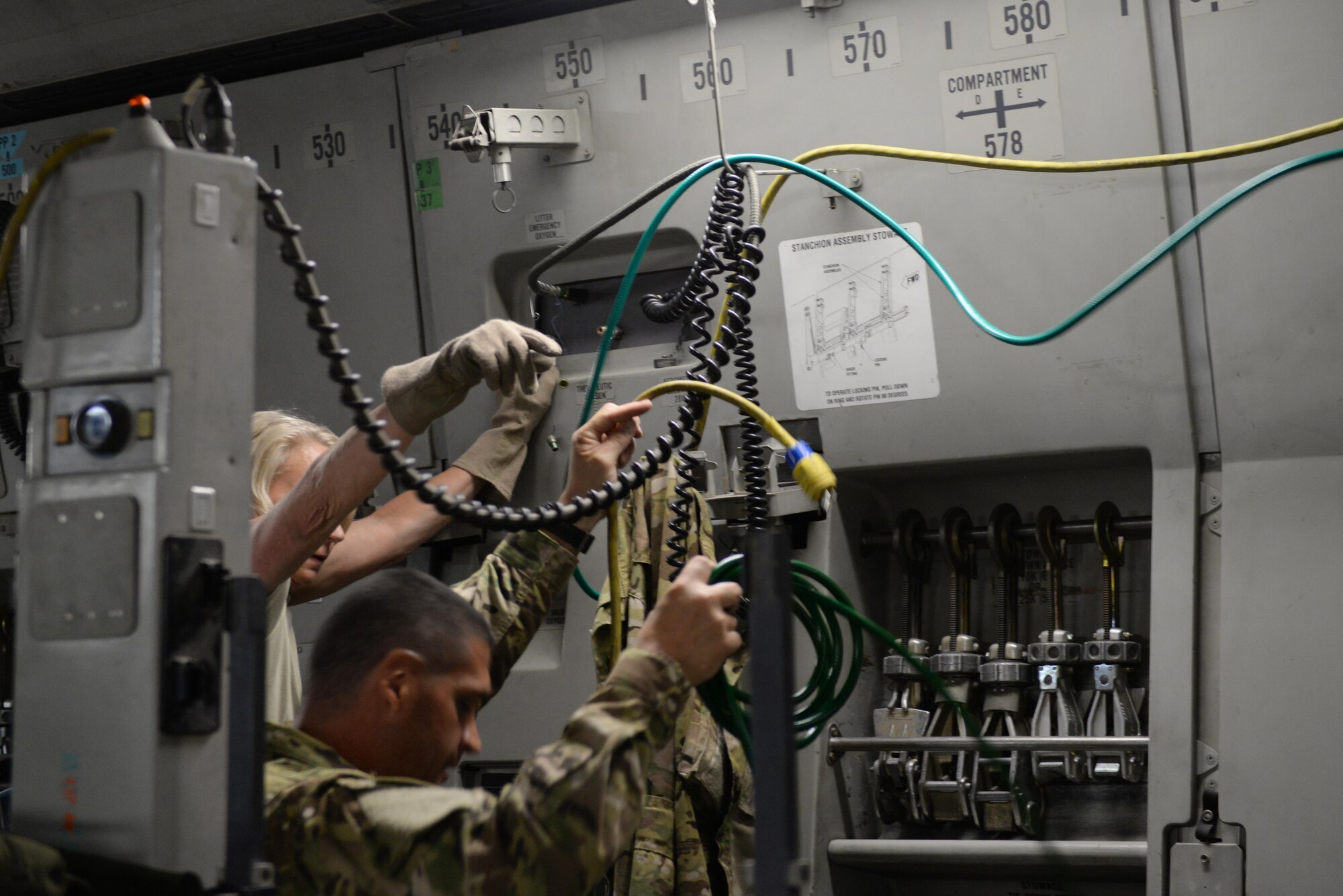 U.S. Air Force Master Sgt. Mary Troja, 455th Expeditionary Aeromedical Evacuation Squadron AE technician deployed from the Air Force Reserve’s 315th AES at Joint Base Charleston, South Carolina, and Tech. Sgt. Russell “Rusty” McLamb, left, 455th Expeditionary Aeromedical Evacuation Squadron AE technician deployed from the North Carolina Air National Guard’s 156th AES, establish electrical and oxygen connections for medical equipment and supplies on a C-17 Globemaster III aircraft on the flight line at Bagram Airfield, Afghanistan, Aug. 9, 2015. The 455th EAES Airmen are charged with the responsibility of evacuating the sick and wounded from Central Command to higher echelons of medical care. (U.S. Air Force photo by Maj. Tony Wickman/Released) 