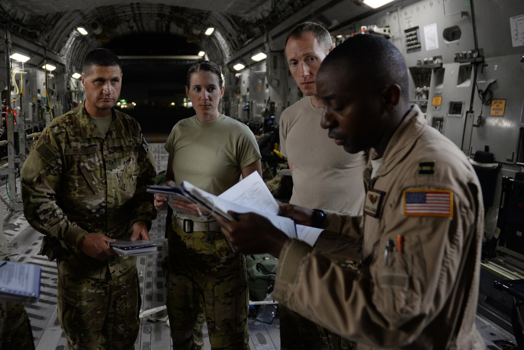 U.S. Air Force Senior Airman Margaret “Maggie” Mathewes, center, 455th Expeditionary Aeromedical Evacuation Squadron AE technician deployed from the Air Force Reserve’s 315th Aeromedical Evacuation Squadron at Joint Base Charleston, South Carolina , Tech. Sgt. Russell “Rusty” McLamb, left, 455th Expeditionary Aeromedical Evacuation Squadron AE technician deployed from the North Carolina Air National Guard’s 156th AES,  and Capt. Derek Martindale, right, 455th EAES flight nurse deployed from the 315th AES, go over a crew brief with U.S. Air Force Capt. Mychol Alexander, C-17 Globemaster III pilot with the 816th Expeditionary Airlift Squadron, prior to loading patients onto a C-17 Globemaster III aircraft at Bagram Airfield, Afghanistan, Aug. 9, 2015.  The 455th EAES Airmen are charged with the responsibility of evacuating the sick and wounded from Central Command to higher echelons of medical care. (U.S. Air Force photo by Maj. Tony Wickman/Released)