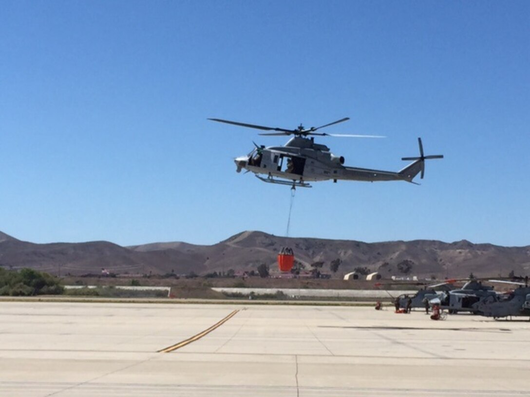 A UH-1Y Huey with Marine Light Attack Helicopter Squadron (HMLA) 469 takes off with a Bambi Bucket to fight wildfires aboard Marine Corps Base Camp Pendleton, California, August 16. The squadron used three helicopters to conduct 44 air drops and complete the mission within three hours of the initial drop. 