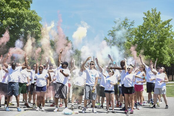 910th Airlift Wing members throw colored powder into the air to start a color run sponsored by the 5/6 Council here, August 2. The color run was a 5k race as part of Family Day activities. Family Day is an annual event allowing Wing members to bring their family to the base for a day of fun and educational activities with their unit. (U.S. Air Force photo/Staff Sgt. Rachel Kocin)