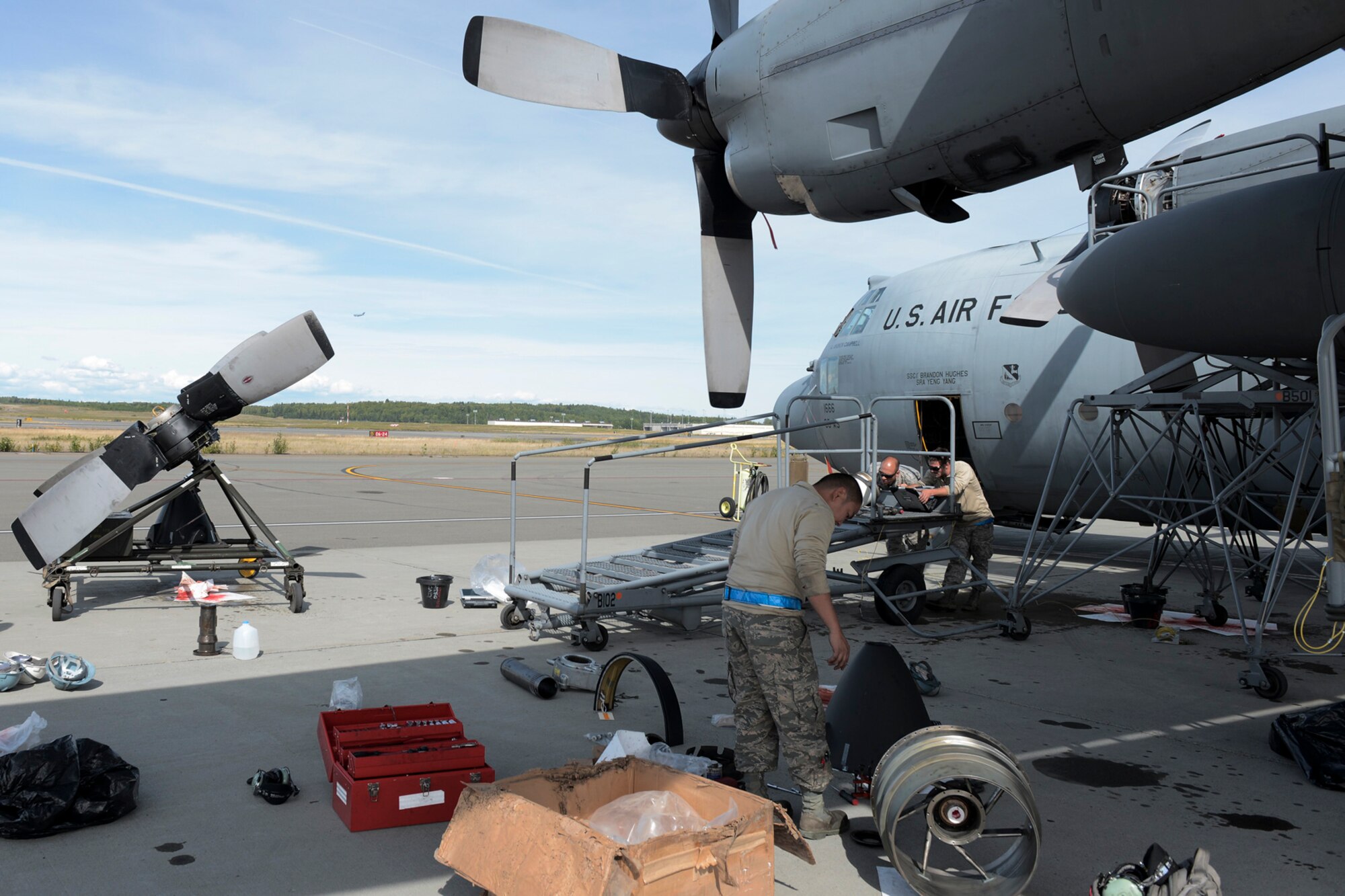 U.S. Air Force Airmen with the 374th Aircraft Maintenance Squadron refer to instructions on replacing a C-130 Hercules propeller during RED FLAG-Alaska at Joint Base Elmendorf-Richardson, Aug. 13, 2015. Maintainers, depending on the needs of the aircraft, work up to 16 hours a day to ensure the C-130 Hercules are ready for flights everyday during RFA. (U.S. Air Force photo by Staff Sgt. Cody H. Ramirez/Released)