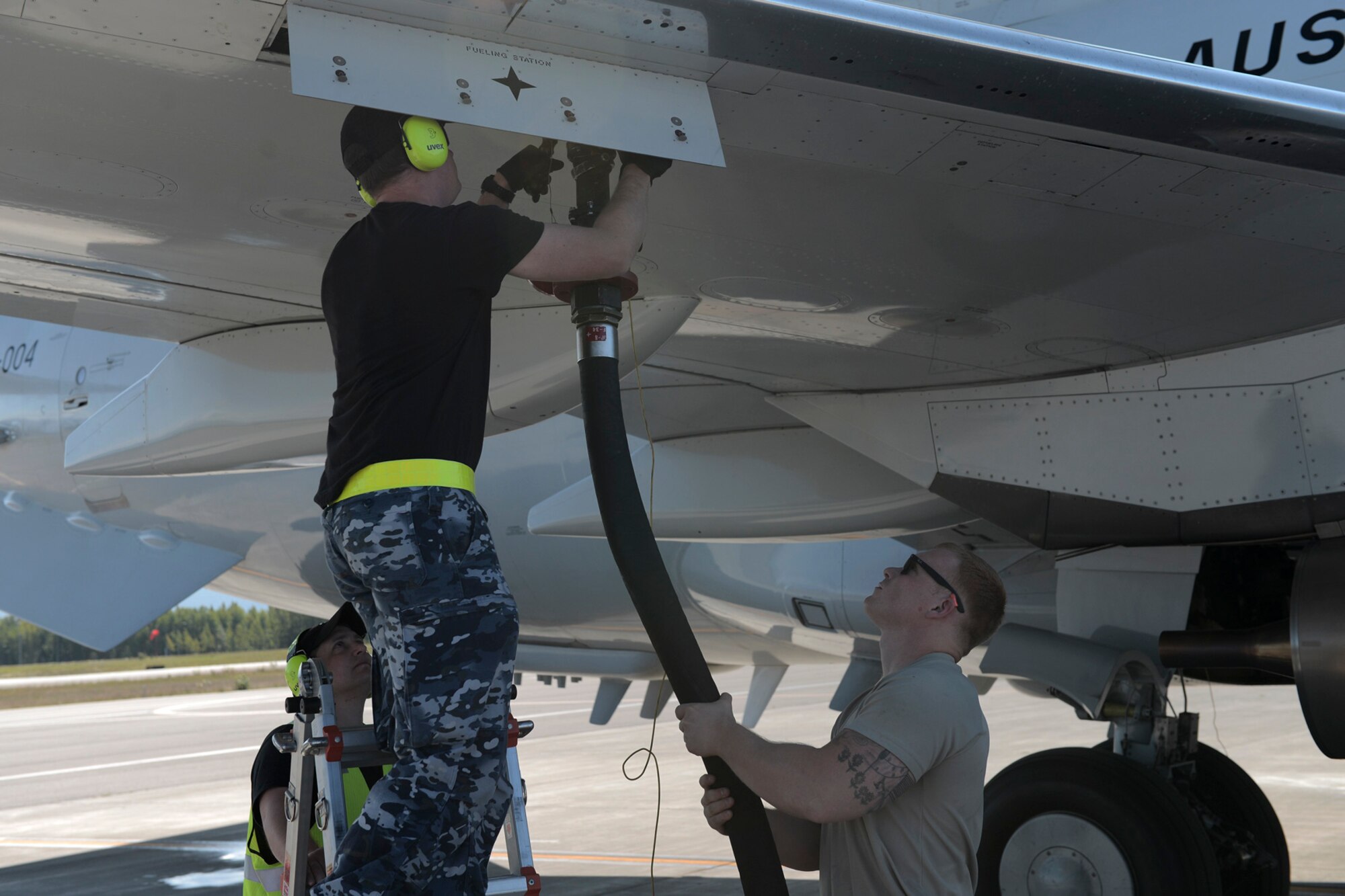 (Left) Mark Dunn and (center) Kayne Markham, Royal Australian Air Force leading aircraftsman with the 42 Wing, 2 Squadron, work with U.S. Air Force Senior Airman Reinhardt Andersen to refuel an E-3 Sentry during RED FLAG-Alaska at Joint Base Elmendorf-Richardson, Alaska, Aug. 14, 2015. Andersen, a fuels distribution operator with the 18th Logistical Readiness Squadron out of Kadena Air Base, Japan, is just one member with the Pacific Air Forces deployed to Alaska in support of RFA, gaining experience in multi-national and joint operations. (U.S. Air Force photo by Staff Sgt. Cody H. Ramirez/Released)