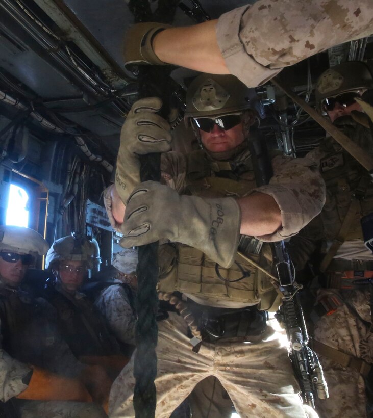 A U.S. Marine with the 13th Marine Expeditionary Unit's Force Reconnaissance Detachment, prepares to slide down the insertion rope of a CH53-E Helicopter during Fast Rope training as part of a predeployment package on Aug. 12, 2015. Fast Roping allows Marines to be placed onto almost any target zone rapidly with almost any weapons in the Corps' arsenal. (U.S. Marine Corps photo by Sgt. Paris Capers/ RELEASED)