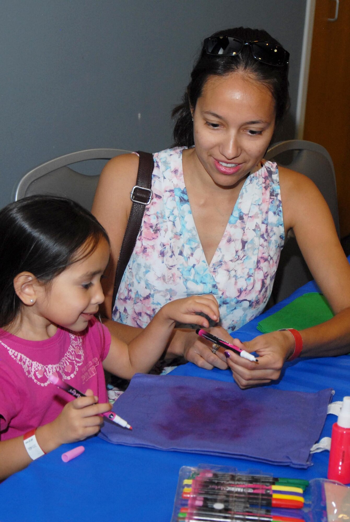 Ruby Y. Naranjo, Bounce Back to School Family Night participant, helps her daughter decorate a bag during the Bounce Back to School Family Night at the Event Center on Goodfellow Air Force Base, Texas, Aug. 17, 2015. During the event, volunteers filled the bags with donated school supplies to help with the new school year. (U.S. Air Force photo by Senior Airman Joshua Edwards/Released)