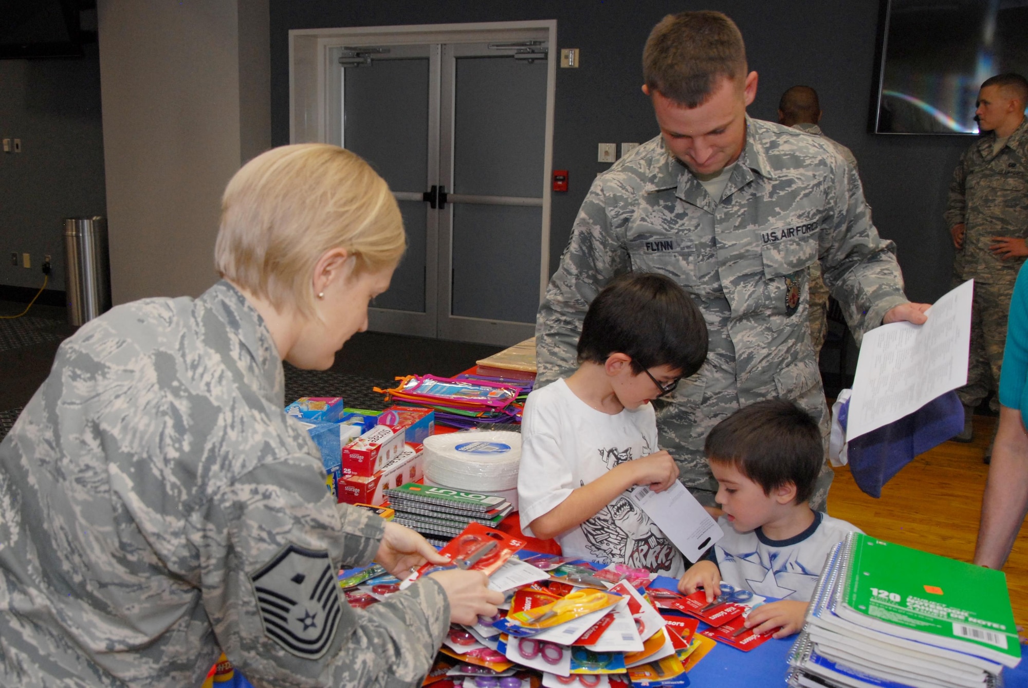 Master Sgt. Brenda J. Dodson, 17th Force Support Squadron first sergeant, assists a military family with school supplies during the Bounce Back to School Family Night at the Event Center on Goodfellow Air Force Base, Texas, Aug. 17, 2015. The event featured bounce houses as well as arts and crafts for the children. (U.S. Air Force photo by Senior Airman Joshua Edwards/Released)