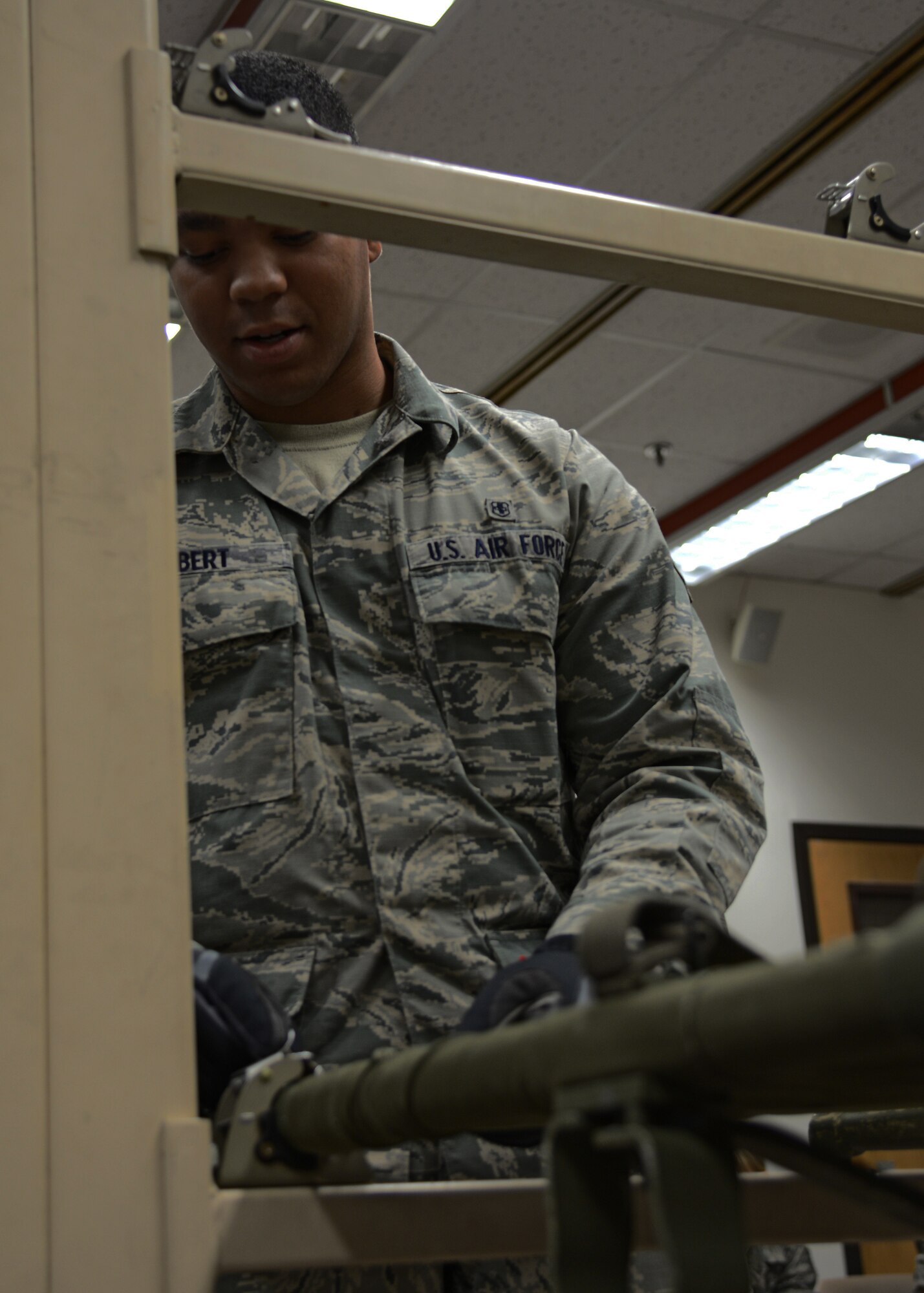 Senior Airman Jeroyd Gobert, 51st Medical Operations Squadron surgical technician, demonstrates how to lock in a litter to a station within the hospital patient staging area on Osan Air Base, Republic of Korea, Aug. 18, 2015.  The patient staging area is where casualties are held before they are moved to a safer location to receive follow-on care. The patient staging area can hold approximately 130 patients. (U.S. Air Force photo/Tech. Sgt. Travis Edwards)