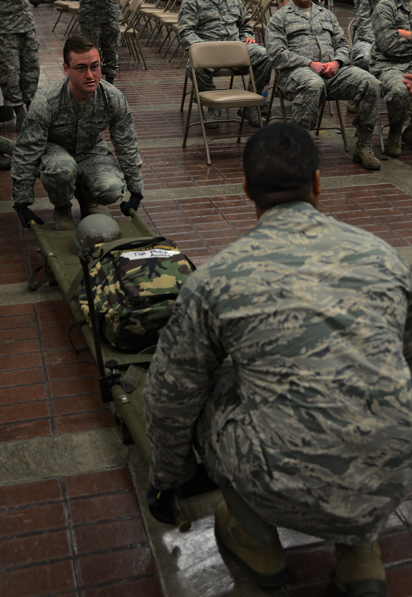 Senior Airman Timothy Burnett, 51st Aerospace Medical Squadron bio-environmental engineer and Senior Airman Jeroyd Gobert, 51st Medical Operations Squadron surgical technician, demonstrate how to lift a litter in order to place it onto a station within a patient staging area on Osan Air Base, Republic of Korea, Aug. 18, 2015.  The patient staging area is where casualties are held before they are moved to a safer location to receive follow-on care. The patient staging area can hold approximately 130 patients. (U.S. Air Force photo/Tech. Sgt. Travis Edwards)