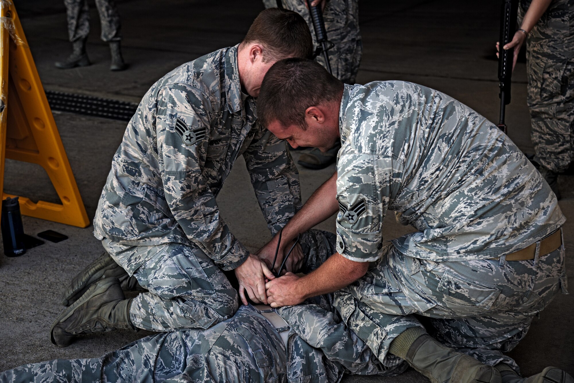 Senior Airmen Cody Murphy and William Garrett, 51st Medical Group security team members, detain a simulated uncooperative person during a training class on Osan Air Base, Republic of Korea, Aug. 18, 2015. The security team spent the day training 51st MDG members on proper security protocols and use of force prior to an impending exercise. (U.S. Air Force photo/Tech. Sgt. Travis Edwards) 
