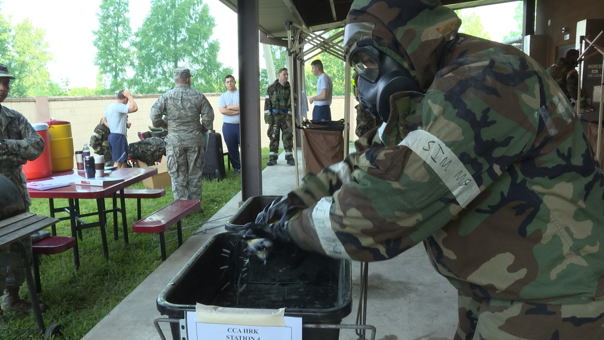 An Airman assigned to the 51st Fighter Wing practices washing simulated contamination off his gloves Aug. 18, 2015, at Osan Air Base, Republic of Korea. Approximately 25 Airmen were processed every hour through the decontamination stations and safely entered the collective protection system dormitory. The CPS is a standby system within designated facilities that is activated when there is a chemical or biological threat. (U.S. Air Force photo by Staff Sgt. Benjamin Sutton)
