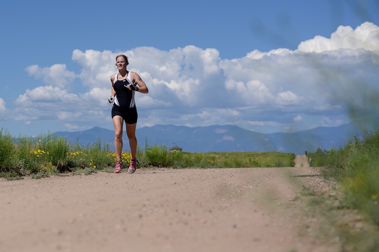 Jennifer Titkemeier, Air Force Space Command, completes the final stage of the 11th annual Schriever Air Force Base Triathlon, Friday, Aug. 14, 2015, on the running trail at Schriever Air Force Base, Colorado.  Titkemeier took first place in the female division, completing the 800-meter swim, 12-mile bike, and 3.1-mile run in 1:27:30. (U.S. Air Force photo/Christopher DeWitt)