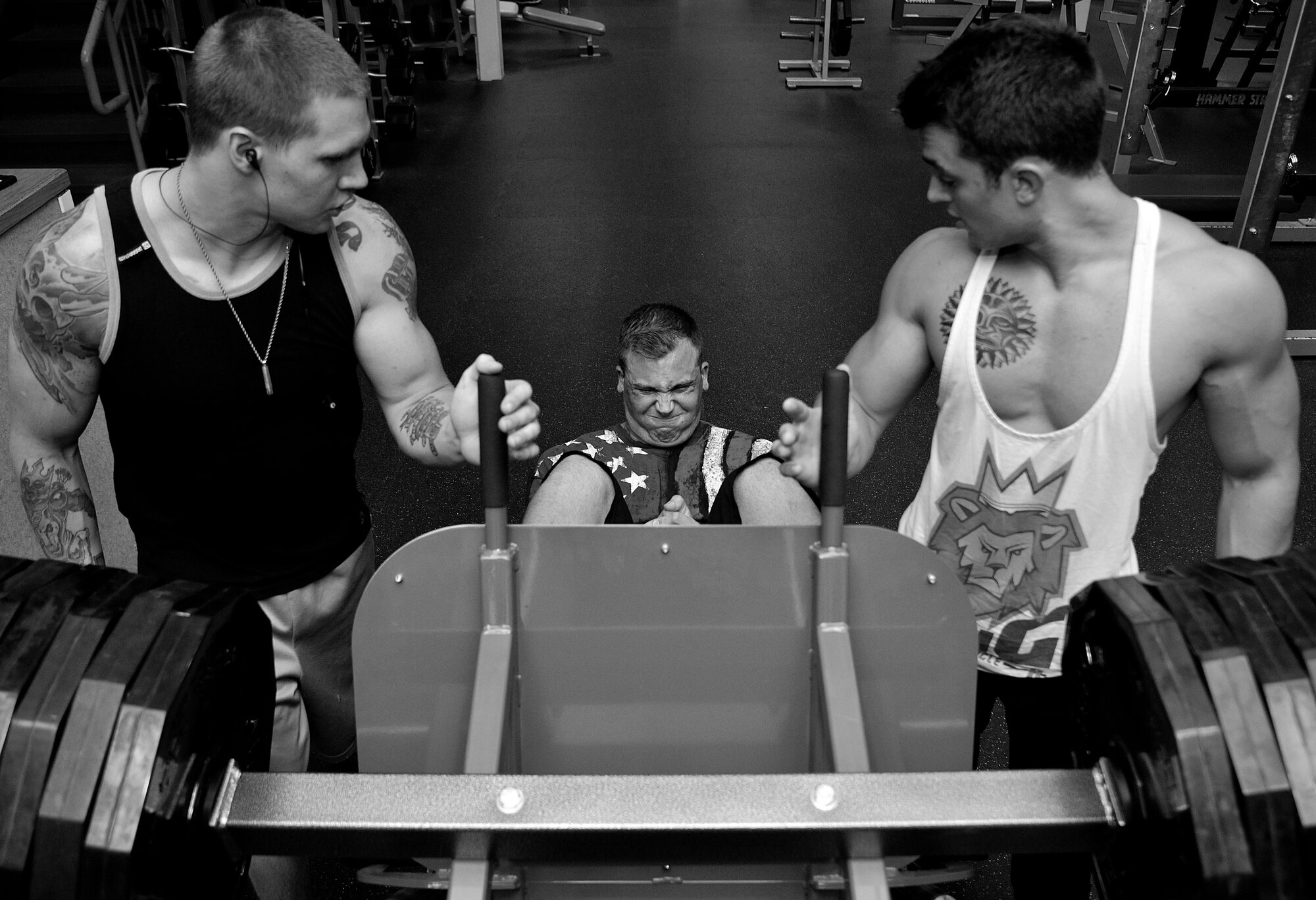 (Left) Senior Airman Charles Buchanan III, 69th Maintenance Squadron aircraft metals technology journeyman, and (right) Airman 1st Class Dakota Stantz, 69th MXS aircraft structural maintenance journeyman, provides motivation as (center) Senior Airman Paul Dell, 319th Logistics Readiness Squadron vehicle operator, leg presses 540-pounds during a drop set during his leg routine at the fitness center on Grand Forks Air Force Base, North Dakota on Aug. 12, 2015. The gym helps build comradery and motivates Airmen to participate proper aerobic conditioning, strength and flexibility training, and healthy eating. (U.S. Air Force photo by Senior Airman Xavier Navarro/released)