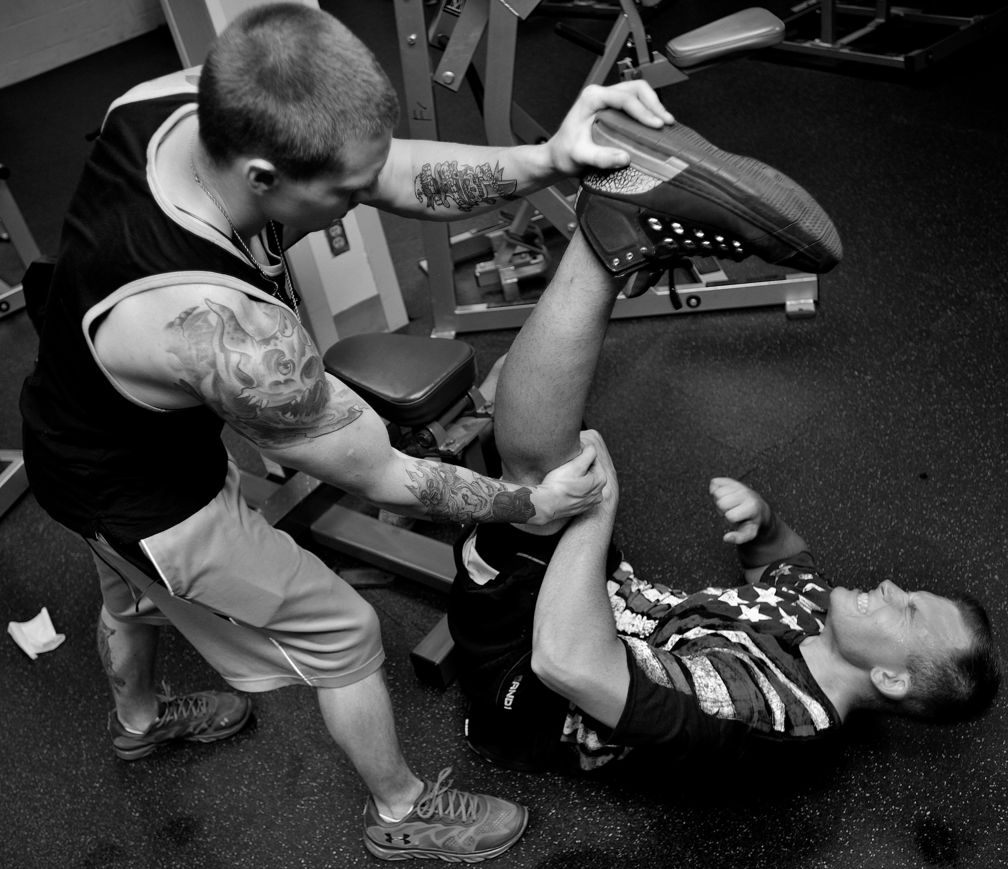 Senior Airman Charles Buchanan III, 69th Maintenance Squadron aircraft metals technology journeyman, helps Senior Airman Paul Dell, 319th Logistics Readiness Squadron vehicle operator, and stretch out his legs after his last set of calf raises at the fitness center on Grand Forks Air Force Base, North Dakota on Aug. 12, 2015. Socializing at the gym helps develop one of the four pillars of Comprehensive Airman Fitness. Airmen who trust each other’s friendship foster good communication. (U.S. Air Force photo by Senior Airman Xavier Navarro/released)