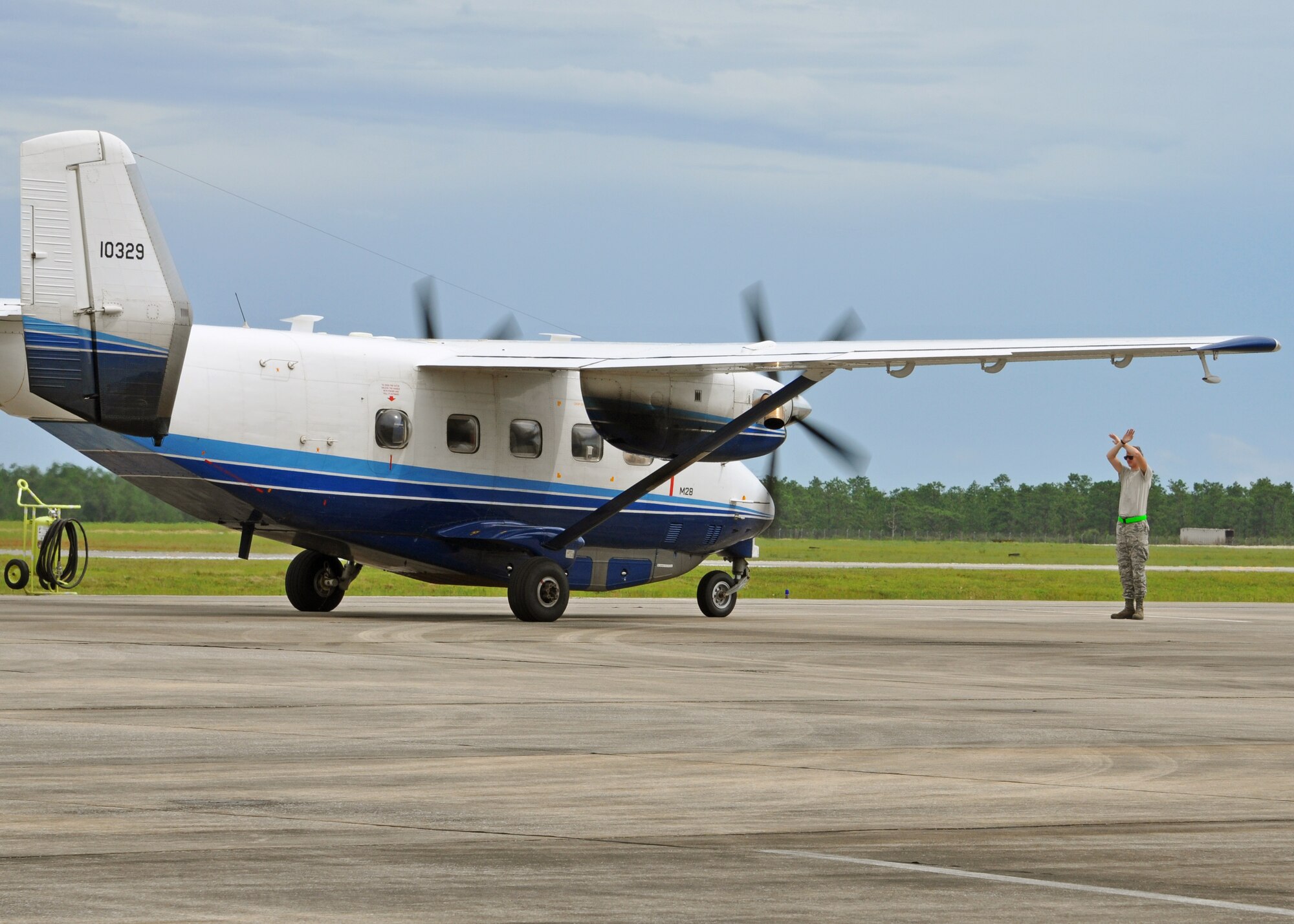 A maintainer marshals a taxiing C-145A into its parking spot at Duke Field,
Fla., Aug. 17 after it and its sister aircraft returned home together from a
lengthy overseas operational deployment.  The Air Force Special
Operations Command-owned aircraft was one of two Duke-based C-145s flying
their final non-standard aviation missions before their imminent retirement
to the Boneyard.  (U.S. Air Force photo/Dan Neely)
