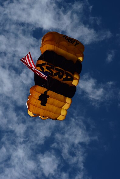 U.S. Army Staff Sgt. Mike Koch, U.S. Army Golden Knights parachutist, floats down from a jump during the 2015 Dakota Thunder airshow and open house at Ellsworth Air Force Base, S.D., Aug. 15, 2015. Cook carried the American flag with him during his jump as part of the opening ceremony for the day. (U.S. Air Force photo by Airman 1st Class James L. Miller/Released)