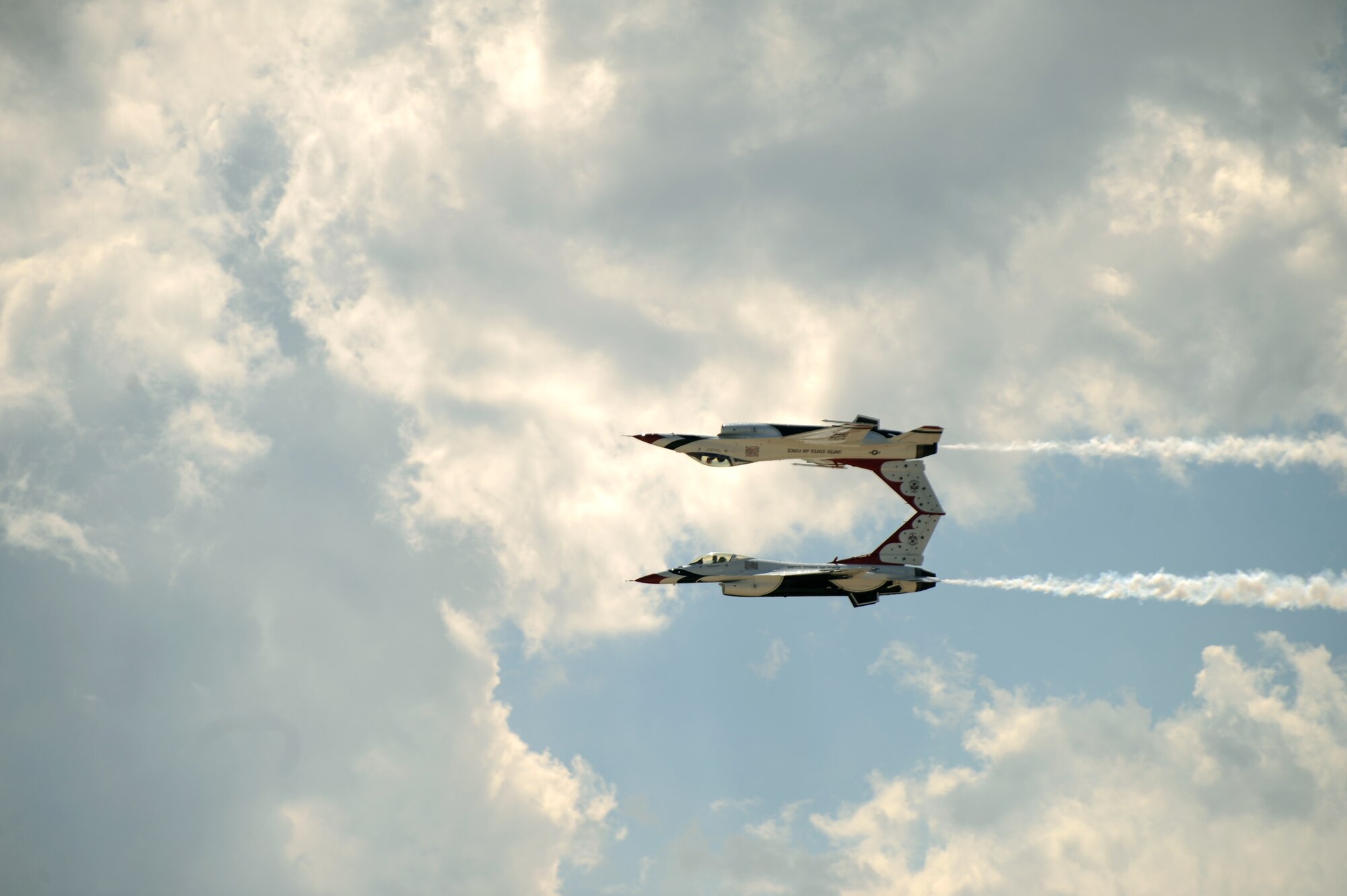 The Thunderbirds perform the calypso pass, an aerobatic maneuver, during the 2015 Dakota Thunder airshow and open house at Ellsworth Air Force Base, S.D., Aug. 15, 2015. Each Thunderbird F-16 Fighting Falcon is assigned a crew chief and an assistant crew chief to ensure their jet remains mission-ready. (U.S. Air Force photo by Airman Sadie Colbert/Released)