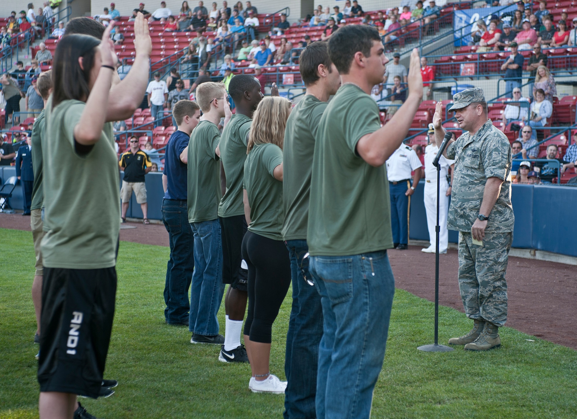 Col. Brian McDaniel, 92nd Air Refueling Wing commander, swears in more than 15 Army and Marine recruits Aug. 15, 2015, at Avista Stadium in Spokane, Wash. McDaniel gave the oath of enlistment to recruits which is a statement that every service member must promise and adhere to for their entire military career. (U.S. Air Force photo/Airman 1st Class Mackenzie Richardson)
