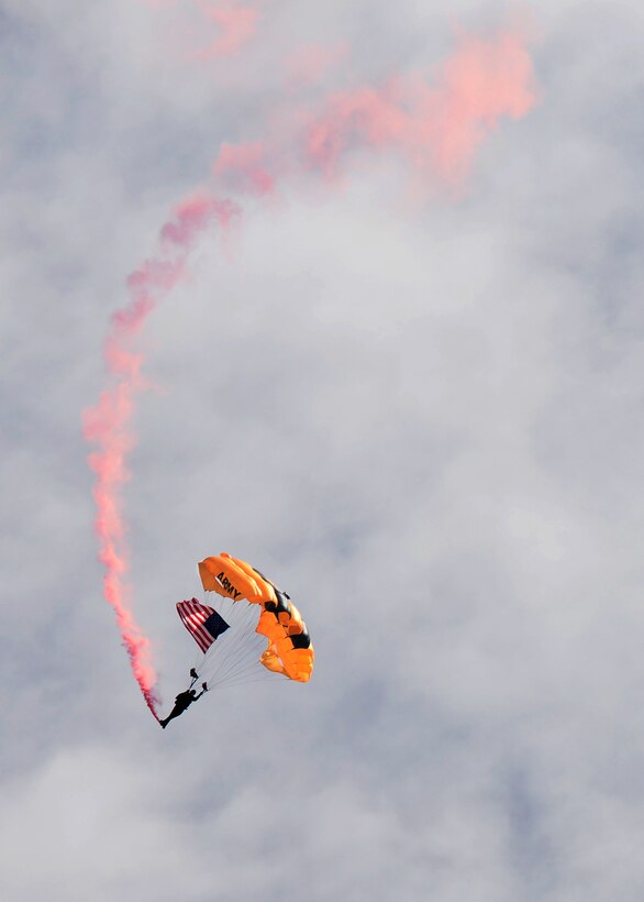 U.S. Army Staff Sgt. Mike Koch, U.S. Army Golden Knights parachutist, performs a jump with the American flag during the national anthem at Ellsworth Air Force Base, S.D., Aug. 15, 2015. As a part of the opening ceremony of the 2015 Dakota Thunder airshow and open house, the Golden Knights completed a 10,000-foot jump onto the flightline. (U.S. Air Force photo by Senior Airman Rebecca Imwalle/Released) 