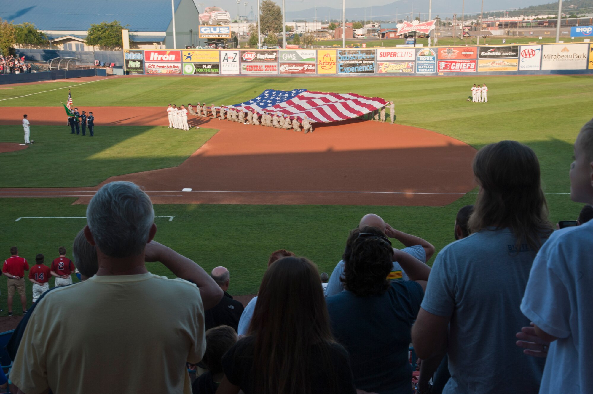 More than 35 Air Force members hold the American flag Aug. 15, 2015, at Avista Stadium in Spokane, Wash. The base honor guard and members from Fairchild Air Force Base were invited to the game to unfurl the flag and present the colors in honor of military appreciation night held by the Spokane Indians. (U.S. Air Force photo/Airman 1st Class Taylor Bourgeous)