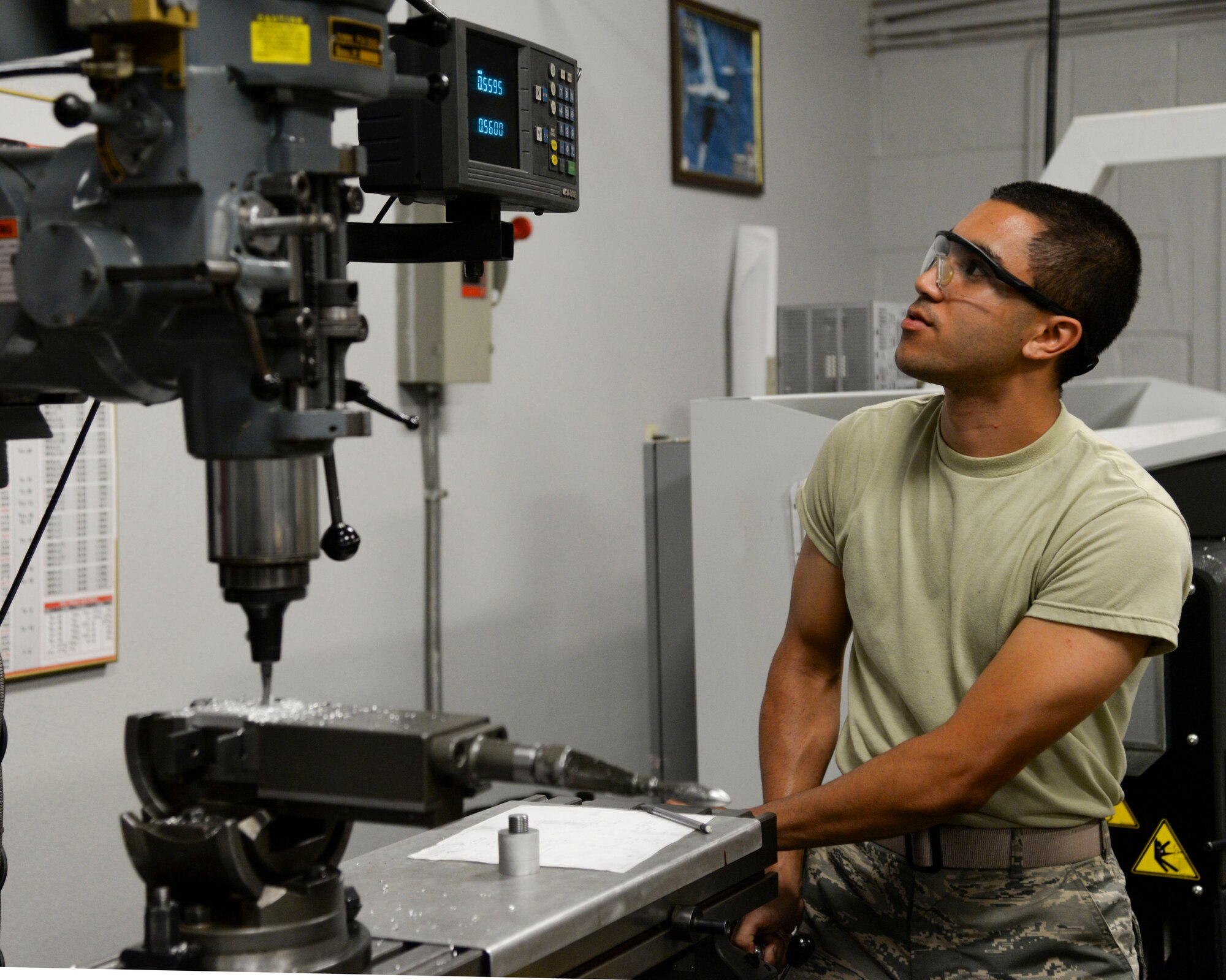 Airman 1st Class Kamiana Jardine, 2nd Maintenance Squadron metals technology apprentice, inspects the settings of a mill while creating a custom part at Barksdale Air Force Base, La., Aug. 4, 2015. Metals tech can take metal and fabricate it into various parts from bushings to brackets. (U.S. Air Force photo/Senior Airman Jannelle Dickey)
