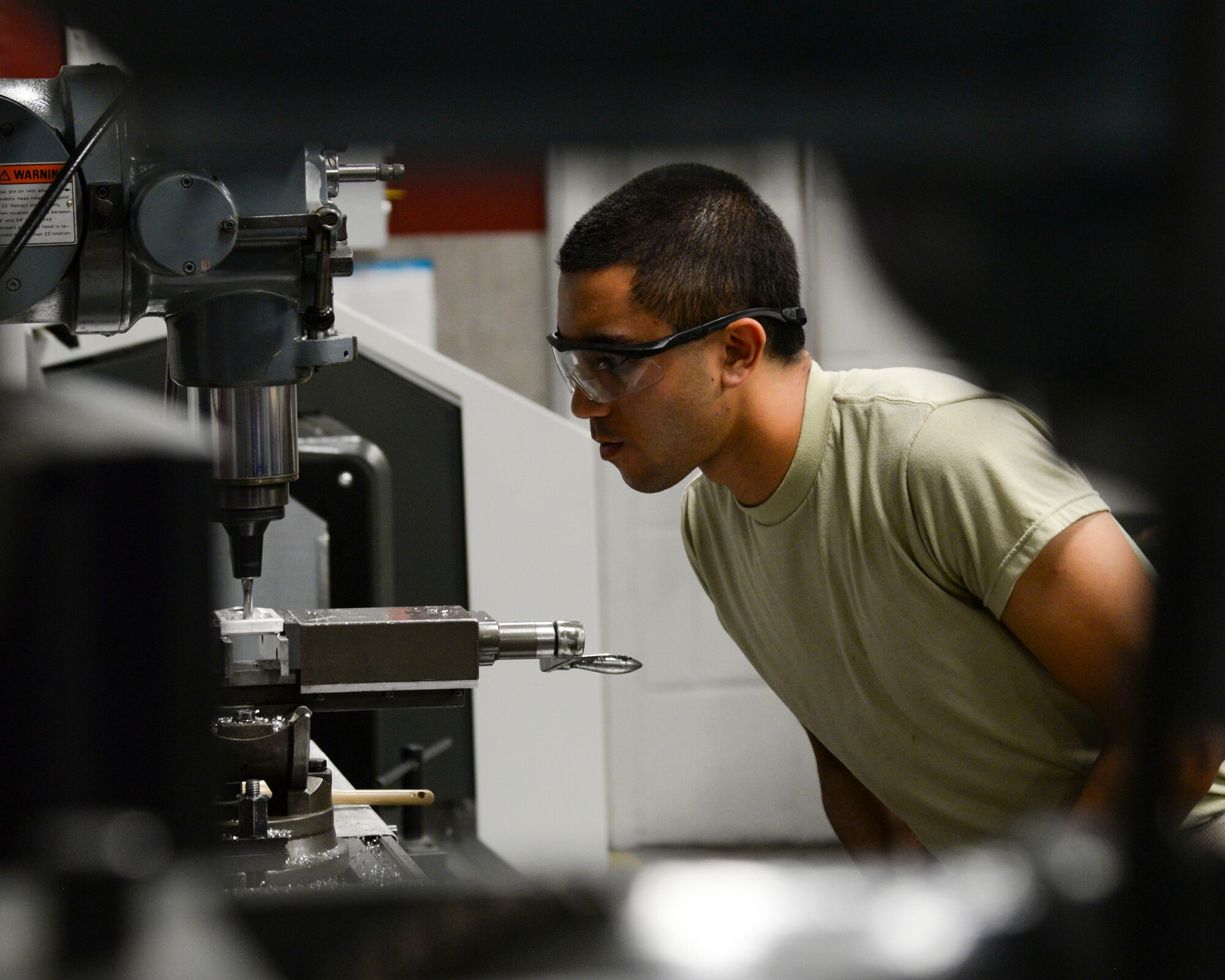 Airman 1st Class Kamiana Jardine, 2nd Maintenance Squadron metals technology apprentice, uses a manual mill to drill and ream holes into metal at Barksdale Air Force Base, La., Aug. 4, 2015. Metals tech Airmen are responsible for designing, welding, repairing and fabricating aircraft and aircraft ground equipment parts. (U.S. Air Force photo/Senior Airman Jannelle Dickey)